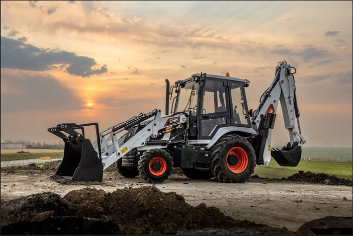 Left side view of a Bobcat B760 Backhoe Loader parked on a site against a cloudy sky.