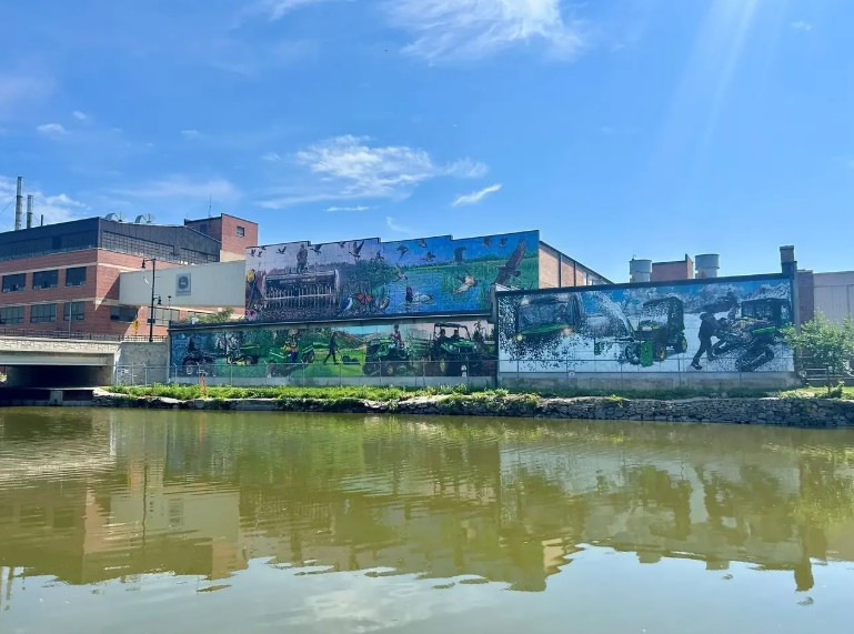 John Deere mural spans Horicon Works factory walls along the river