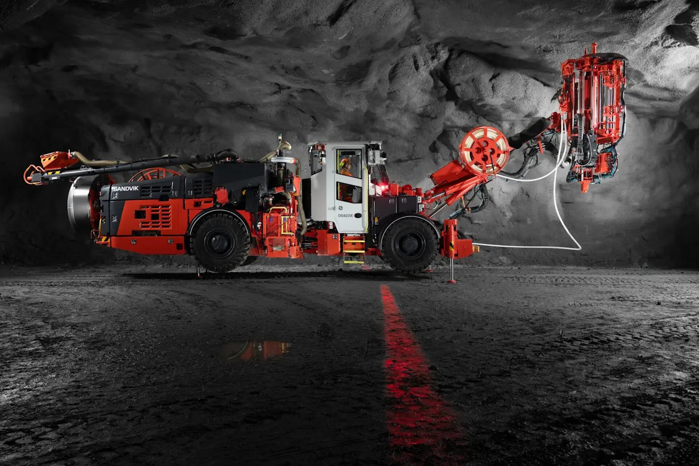 Sandvik DS422iE Battery Cable Bolter working underground in a dark mine.