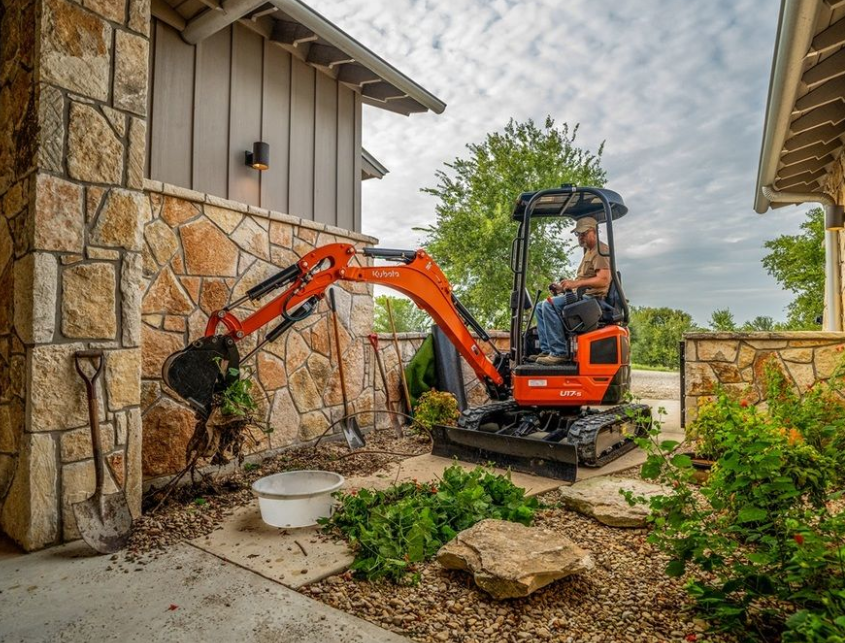 Kubota U17-5 compact excavator operating in a tight urban space.
