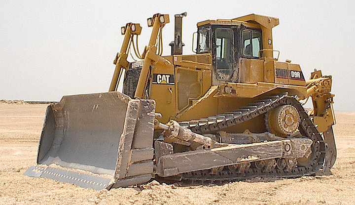 Left side profile of a CAT D9 Dozer parked on a job site.
