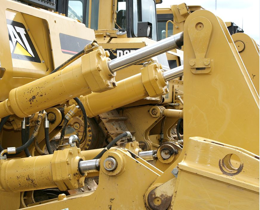 Close up of bulldozer hydraulics that control blade movement, ripper functions, and other attachments.